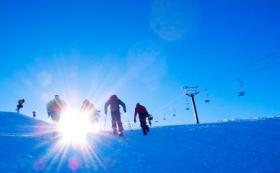 Early skiers hiking Coronet Peak for unofficial preseason turns. Credit: Coronet Peak.