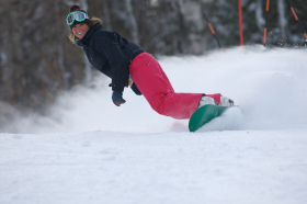 Woman snowboarding the trails at Mount Sunapee.