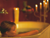A woman relaxes in a tub by candlelight. (ANTO/Webung/Niederstrasser)