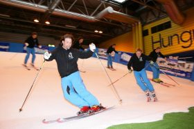 Skiers on an indoor dry slope at the British Ski & Snowboard Show.