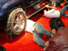 Contestants installing chains on a Jeep Grand Cherokee. Jeep is a sponsor of the National Ski & Snowboard Expo.