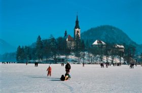 Visitors to Bled walking across its frozen lake.