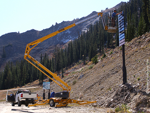 Beefing up the Signage at Crested Butte Mountain Resort : : : : : : : :
The Crested Butte Mountain Resort Mountain Operations Department has dramatically increased the amount of signage on the mountain this fall. They’ve installed several dozen new sign posts and relocated old signs to more visible locations on our ski runs. Driving and biking around the mountain this fall, the new signage has been quite noticeable. I wouldn’t go so far as to say that you won’t be able to get lost on our mountain, but I would think that from just about anywhere on our groomed terrain, there’ll be a sign in sight.
: : : : : : : : Today’s shot is of Mountain Operations Assistant Director, Mark Voegelli, doing a little a . . . well, a little fix it work on the sign at the top of the Paradise Lift. That’s the Headwall with a bit of snow on it in the background. It seems that Peel and Forest had been signed as single black runs, when they are, in fact, double blacks. So those signs had to get swapped out. Somebody on the ground was making heckling comments about how we’re going to groom the Peel now that it’s a single black run . . . probably not.
: : : : : : : : Today was a glorious day to be on the mountain and elsewhere in the Crested Butte high country. We enjoyed cloudless skies, temps that made short sleeves mandatory accompanied by calm conditions. I was working near the bottom of the High Lift for much of the day on the resort’s new snow stake cam (more to come on that in the next week or two) and reveled in the pleasant weather. We saw more haze from the wild fires burning in states to the west of us, particularly in the afternoon. Weather forecasters are still showing a mid-week shot of moisture and cooler temps for CB. Looks like things will whiten up a bit by Thursday.
: : : : : : : : That’s it for me today . . . stop back by tomorrow and we’ll do it again.