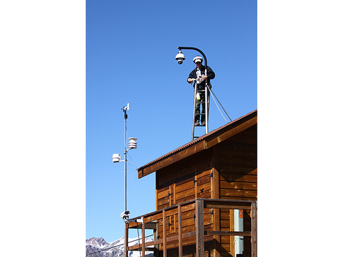 Fall Cleaning for the Mike Nelson Cam at the Top of Gold Link : : : : : : : :
Tuesday’s shot is of yours truly cleaning the glass bowl on the Mike Nelson cam at the top of Gold Link. And here you thought that being the phone and shot of the day guy at Crested Butte Mountain Resort was all fluff and glamour! There’s some dirty and tricky work involved, too—just look! It’s tough to tell from this angle, but the only way to access the cam is to find the longest extension ladder the resort owns, set it on the downhill side of the shack, get one of your coworkers to hold it for you and extend it all the way so that it gets you up to cam level. I had more stuff to hang on to than I had hands available, so I parked the bowl on my head while I prepped for the cleaning.
: : : : : : : : Mike Nelson uses time lapses from this cam on his 7News weather forecasts. I don’t have the television at my house hooked up to anything but the DVD player, so I haven’t been able to see the fruits of my cleaning labor. But hopefully some of you catch some views from the Mike Nelson cam and are enjoying it!
: : : : : : : : I’d take another three or four weeks of days like Monday if I could get them in Crested Butte. The sun was out, breezes were light and temps topped out in the mid fifties. The single track on the mountain was dry and persistently called to me this afternoon. It was so hard to resist! Seeing a little more fall before winter advances further down the mountains would be pretty okay in my book. Another fabulous Crested Butte winter will be here before we know it, regardless. Only, what, 42 days until we open for skiing? It’s just around the corner . . .
