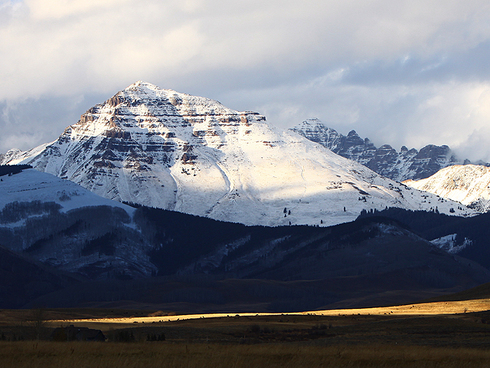 Heading for the Weekend with Gorgeous, Snowcapped Mountain Views       : : : : : : : :   
Howdy Crested Butte Fans . . . are you ready for the weekend, or what?  I’m not sure what things are looking like in your part of the world, but in CB, we’re on track for a gorgeous couple of days off.  The forecast is still calling for sunny skies and temps that will touch sixty degrees, so I’m looking forward to some two-wheeler time for sure.  While the single track around CB probably needs a couple of days to dry out, the trails around Gunnison should be in primo shape!
       : : : : : : : :   Today’s shot is from the drive home on Thursday evening.  Tough views on the commute, huh?  We manage to muddle through some how in the Gunnison Country.  That’s Teocalli Mountain wearing a fresh coat of snow.  We had more frozen moisture come through the Crested Butte area Thursday, mostly midday.  The snow level was probably around 10,000 feet.  The upper mountain at Crested Butte Mountain Resort reportedly has three or four inches on it.  I have to admit that seeing all of this snow is putting me in the mood to make some turns!  I’m set up with new skis this winter and I’m already looking forward to turning them loose on a big powder day!  Hopefully you’re making room for new boards in your quiver, as well!
       : : : : : : : :   Alrighty . . . it’s time to get on with the weekend!  If you’re on the fence about whether or not to put together a ski trip for you and your crew this winter, take a minute and give one of the extremely knowledgeable and fantastically friendly Crested Butte Vacations representatives a call.  They can suggest plenty of options for the kind of ski adventure you’re looking for, and they love doing it Use the number below to give them a shout.  Have a fantabulous weekend!  
